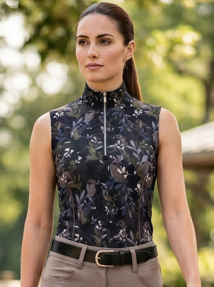 Woman in equestrian attire walking outdoors with trees and a building in the background