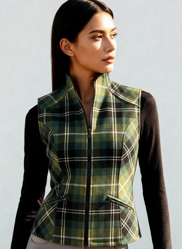 Woman wearing a green plaid vest over a black long-sleeve shirt against a white background